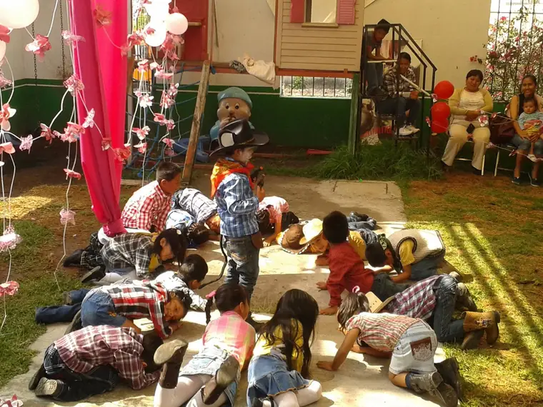 Niños en traje típico durante una representación al aire libre en el jardín de la escuela